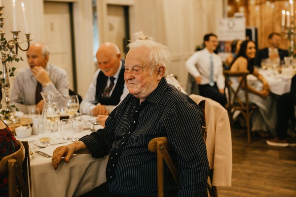 man at table listening to speeches