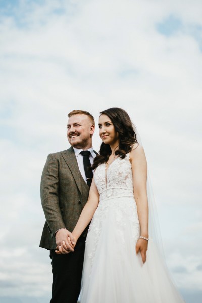 bride and groom hold hands