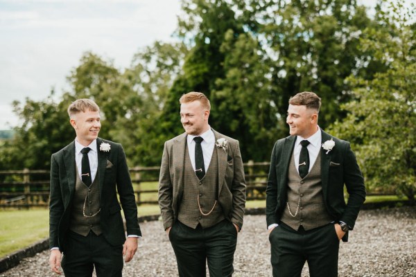 groom and groomsmen pose in the garden