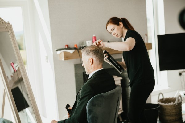 hair stylist gets father ready by doing his hair