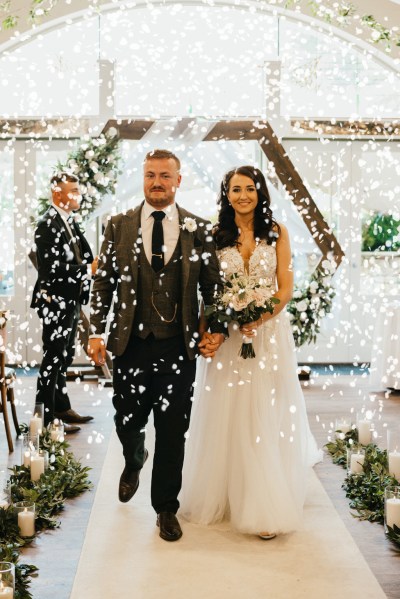 bride and groom exit wedding ceremony confetti being thrown over them