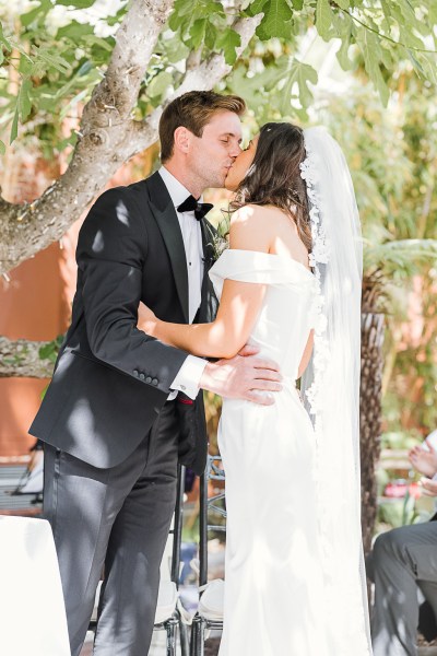 bride and groom kiss at the alter as they greet