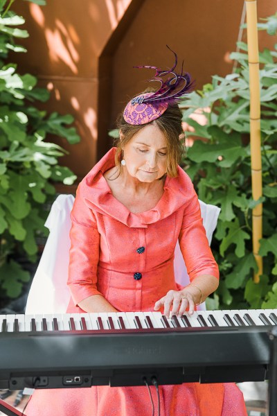 woman in orange dress plays the keyboard piano