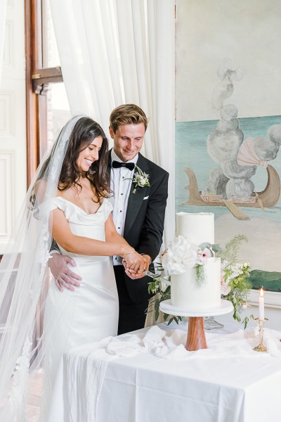 bride and groom cutting the white wedding cake