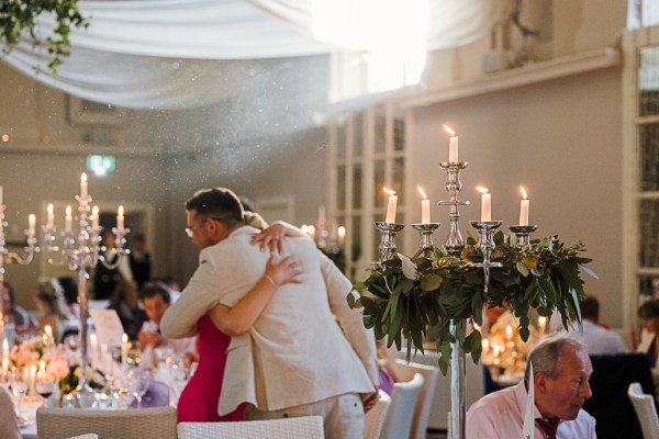 groom hugs woman in ballroom setting