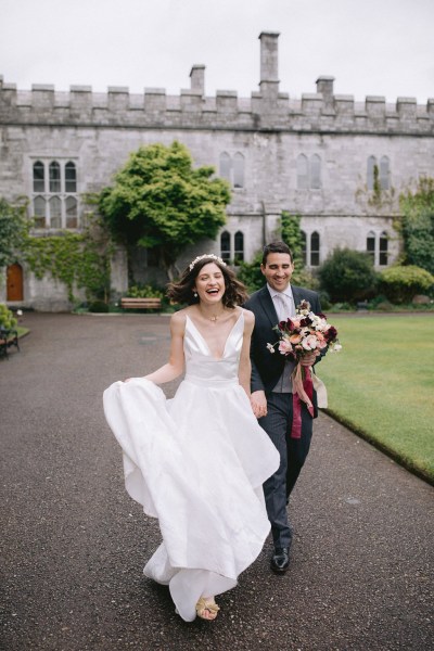 bride and groom walk the pathway venue in background