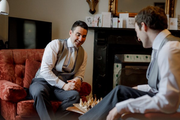 groom sitting in suit with groomsman