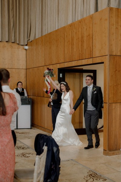 bride and groom enter ballroom dining room hand in hand