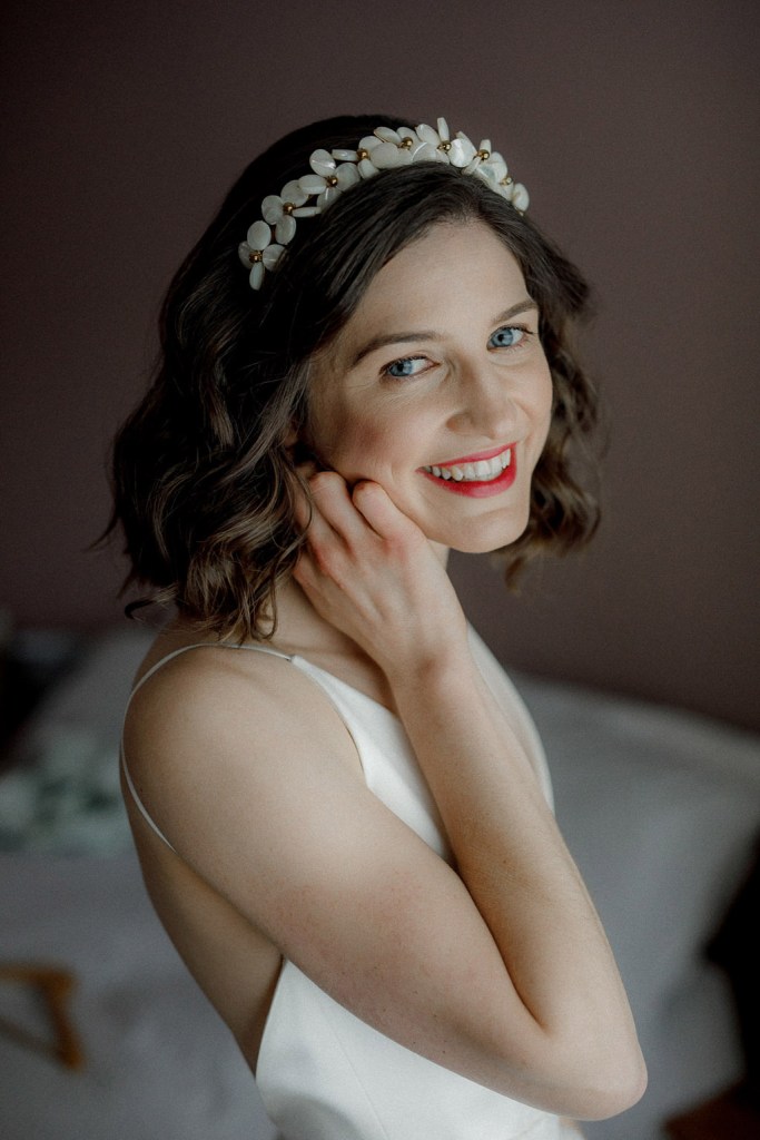 bride putting on her earrings smiling