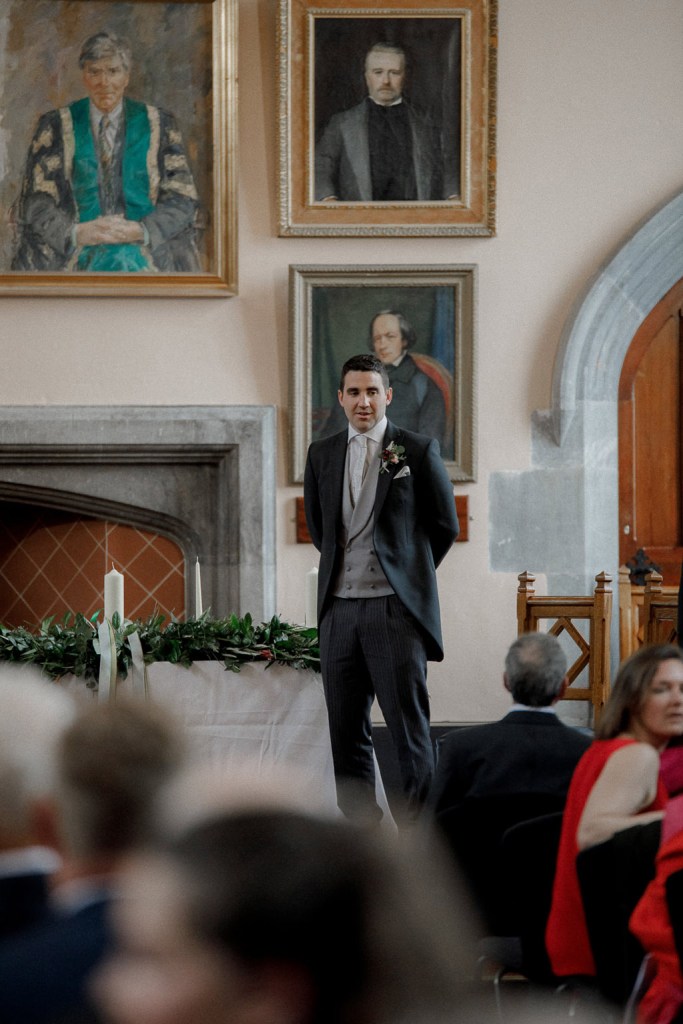 groom at top of alter setting in church