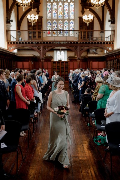 bridesmaids in green walks down the aisle