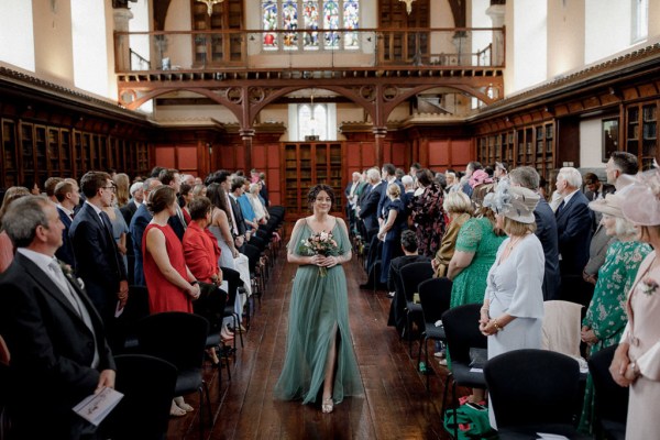 bridesmaids in green walks down the aisle