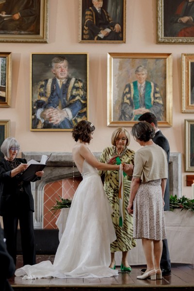 bride and groom are bound with ribbon at top of alter with celebrant and witness