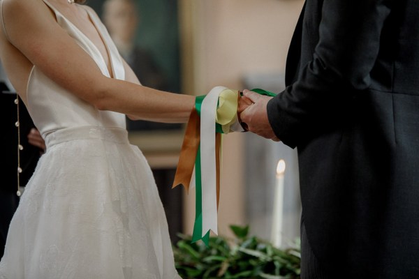 bride and groom are bound with ribbon at top of alter with celebrant and witness