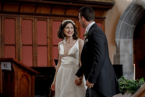 bride and groom smile after being wed they hold hands