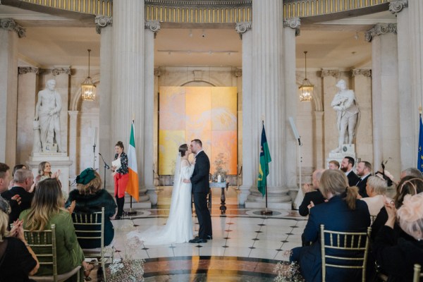 bride and groom kiss at the alter in front of guests