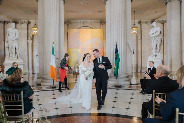 bride and groom exit ceremony as guests clap