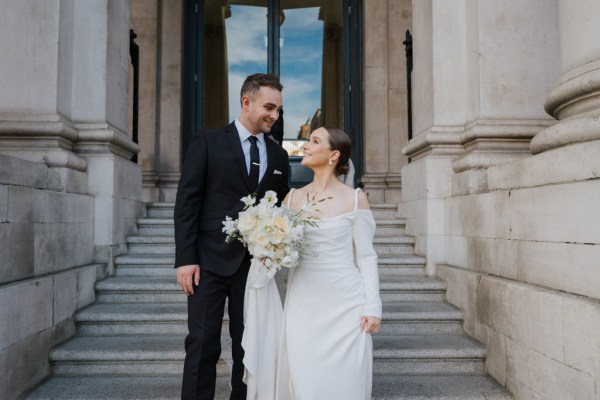 bride and groom are standing on the steps to wedding venue ceremony