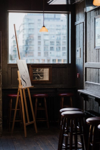 easel wedding sign in pub bar setting stools