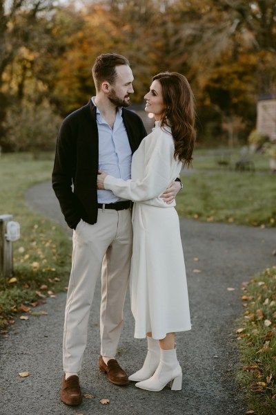 casual bride and groom stand holding each other in garden setting facing each other