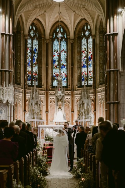 bride groom at alter with priest in chapel church setting