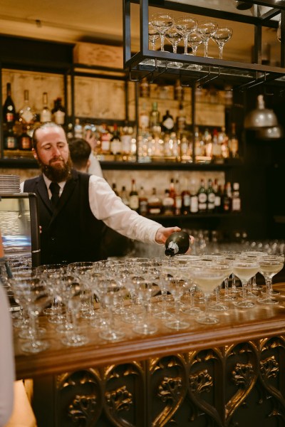 cocktail champagne flutes glasses laid out on table waiter about to serve drinks