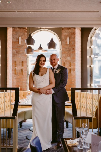 bride and groom holding each other arms around each other