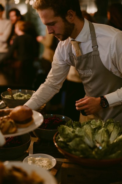 waiter places food on table for guests