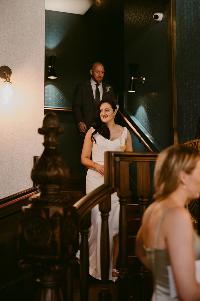 bride and groom make their way down the staircase