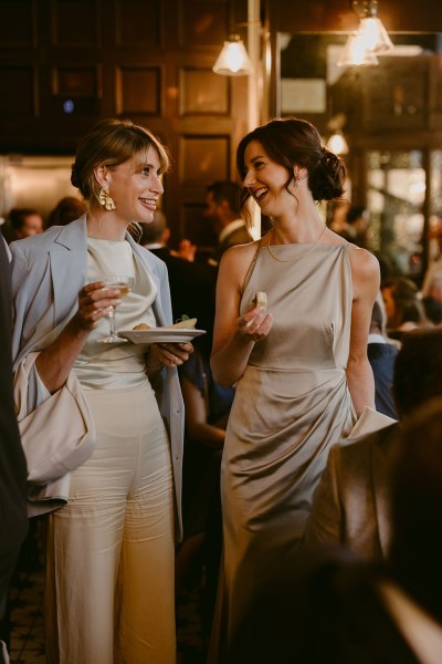 guests stand around eating and chatting