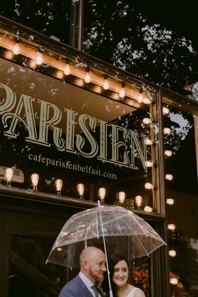 Parisien couple hold up umbrella in rain