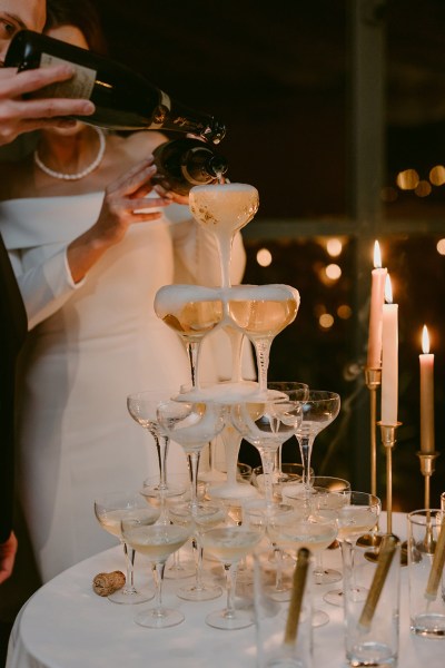 champagne fountain being poured by bride and groom flutes glasses