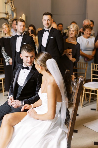 bride and groom face each other she wears veil at top of aisle