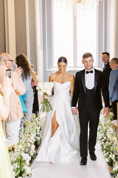 bride and groom are wed they exit ceremony guests clapping