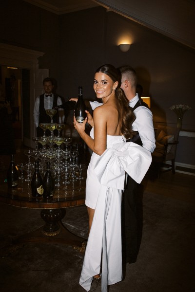 bride holding bottle of champagne or prosecco with groom