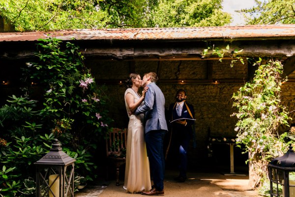 bride and groom kiss at the alter