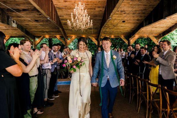 bride and groom are just wed guests clapping