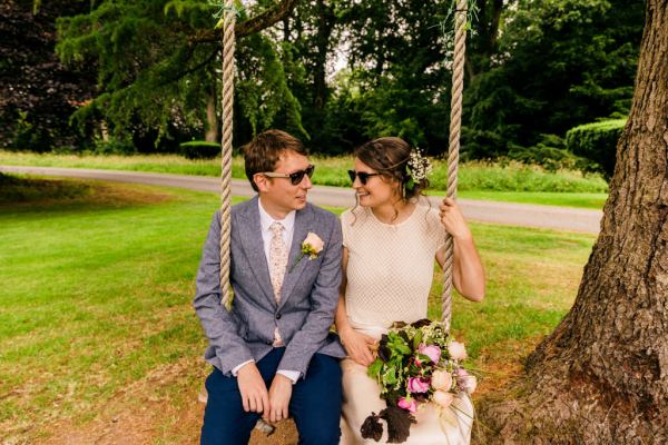 bride and groom on the swing outside in garden