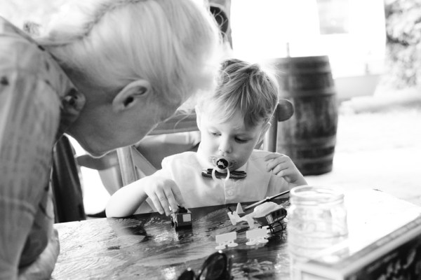 black and white little boy child plays with elderly woman