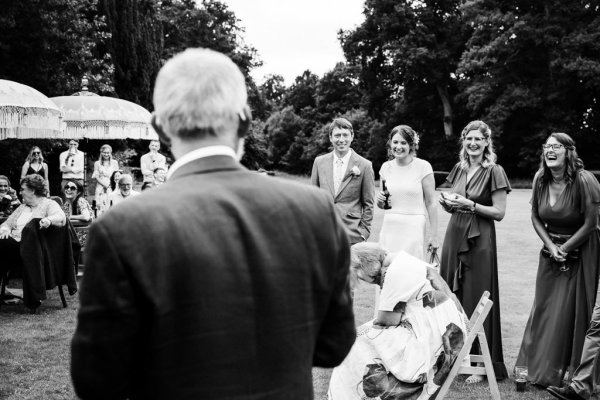 black and white embarrassed laughing emotional woman seated and guests