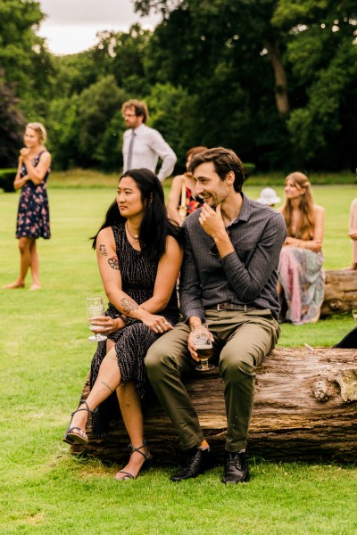 guests seated on tree bark on grass