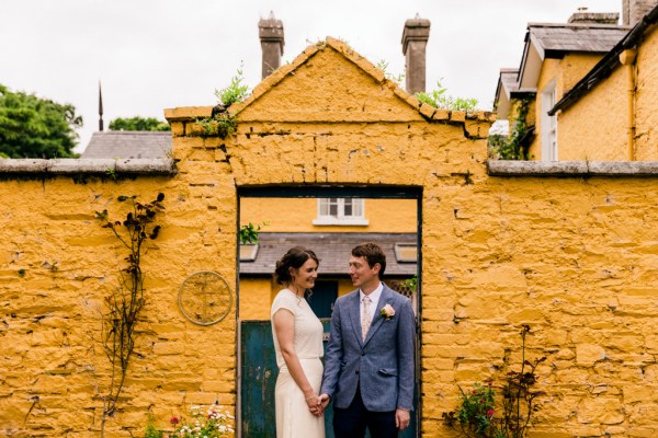 bride and groom hold hands outside of wedding venue