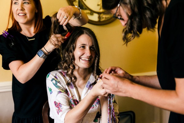 bride laughs and holds hands with mother