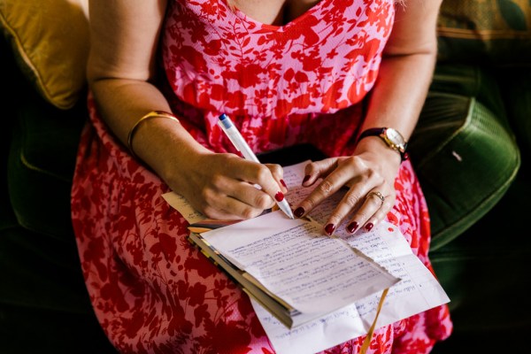 woman in pink dress writing letter/note