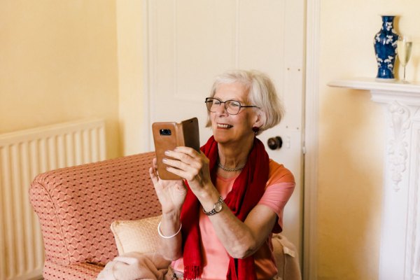 grandmother takes photo of bride