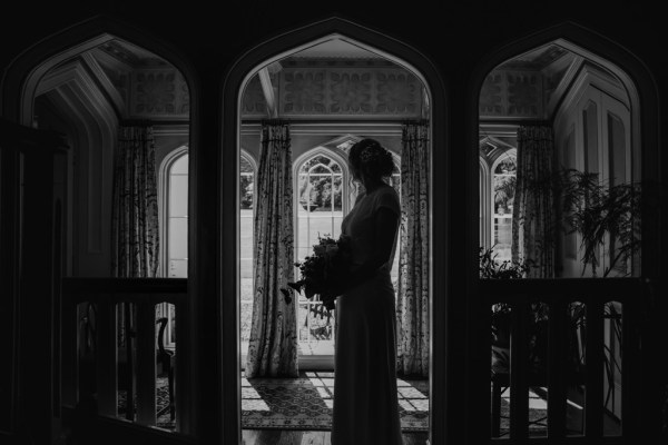 black and white shout of silhouette bride under archway to venue