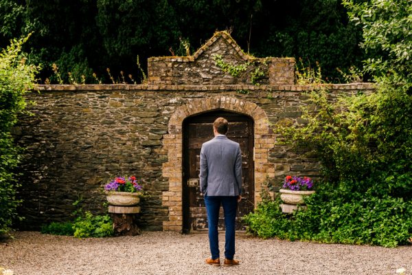 groom awaits his bride in garden