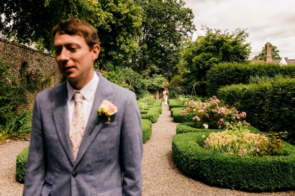 groom awaits his bride in garden