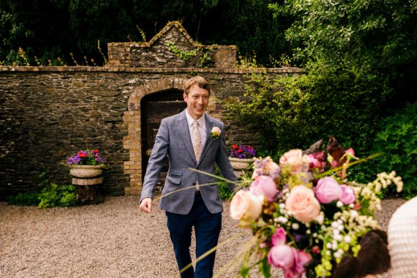 groom sees bride for the first time in garden and approaches her