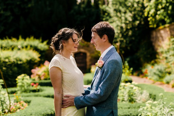 bride and groom hug embrace in garden setting